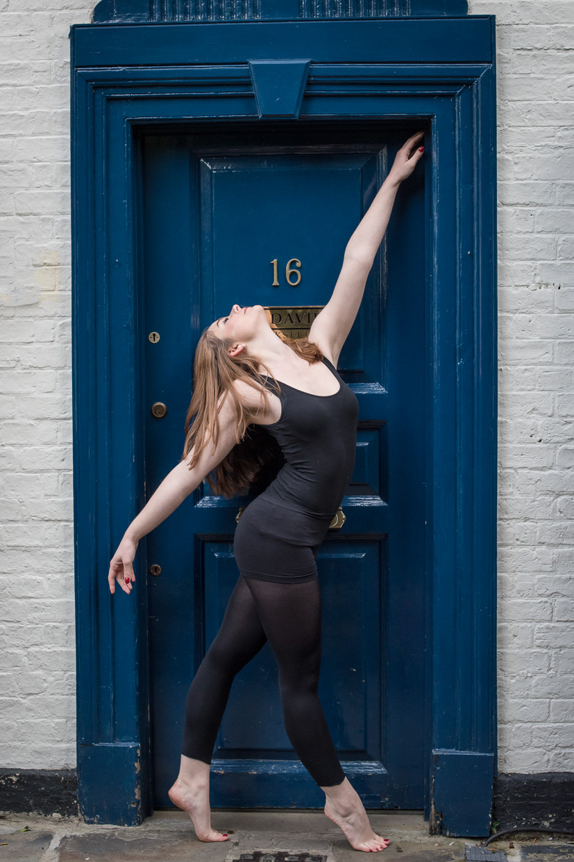 Holly Willis in black, in front of a blue door.