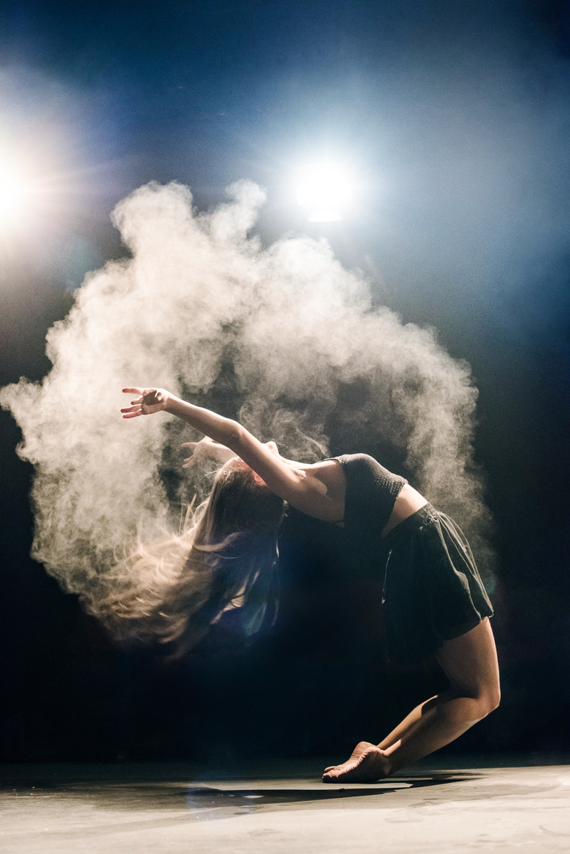 Stefanie Mavrakou arching backwards, in a cloud of talcum powder. At Corpus Playroom, Cambridge.