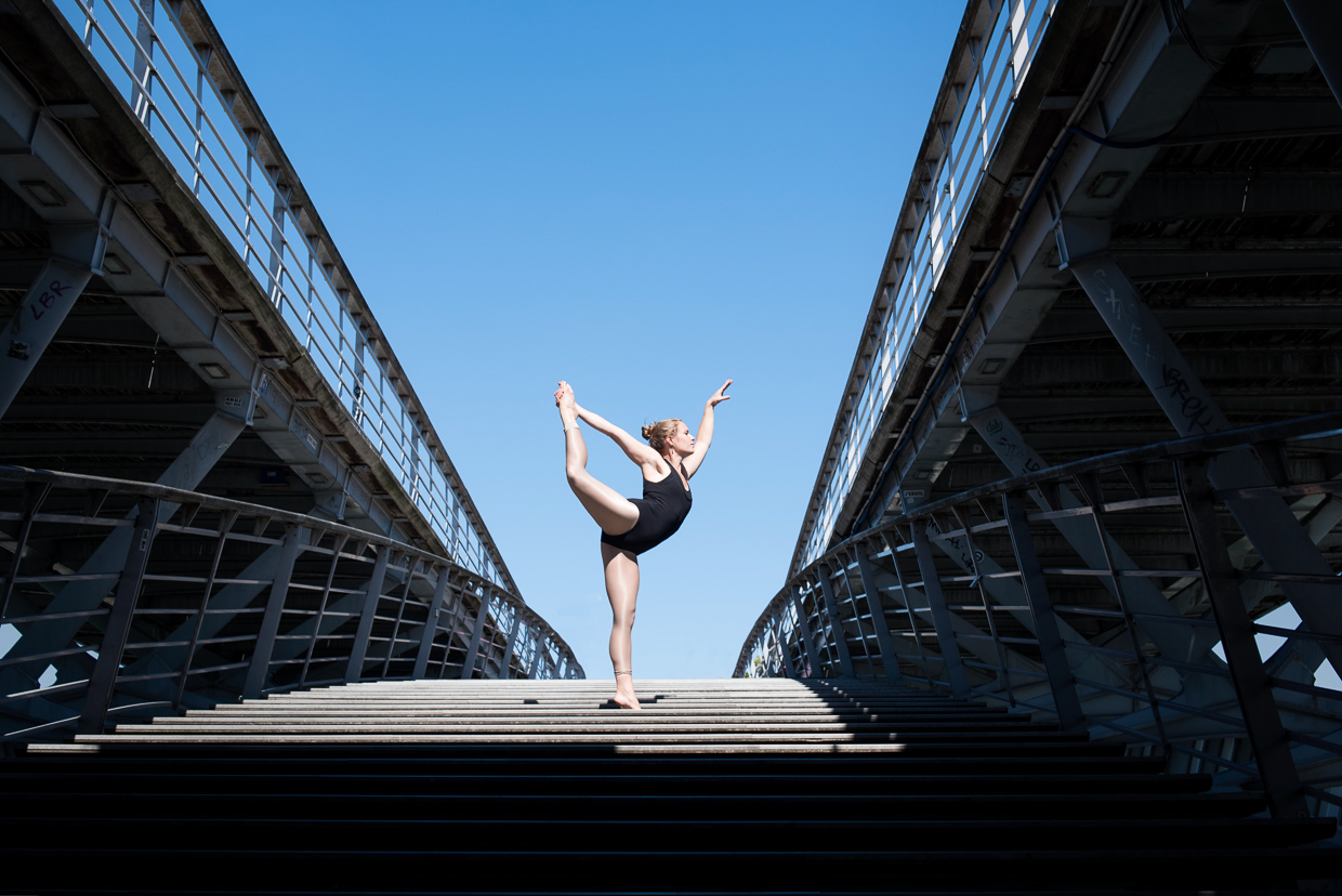 Lucy McMahon doing a ballet pose on a bridge in Paris